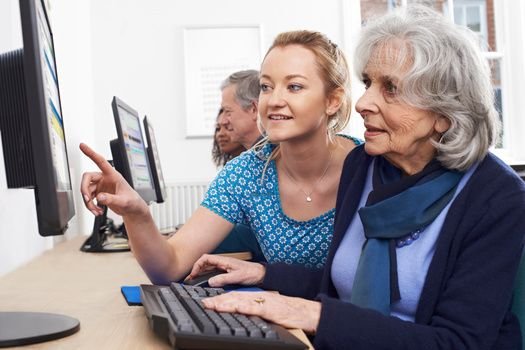 Techniker hilft einem Senior mit einem Laptop